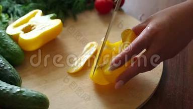 一名妇女在木制砧板上切鲜<strong>黄色甜椒</strong>的特写镜头